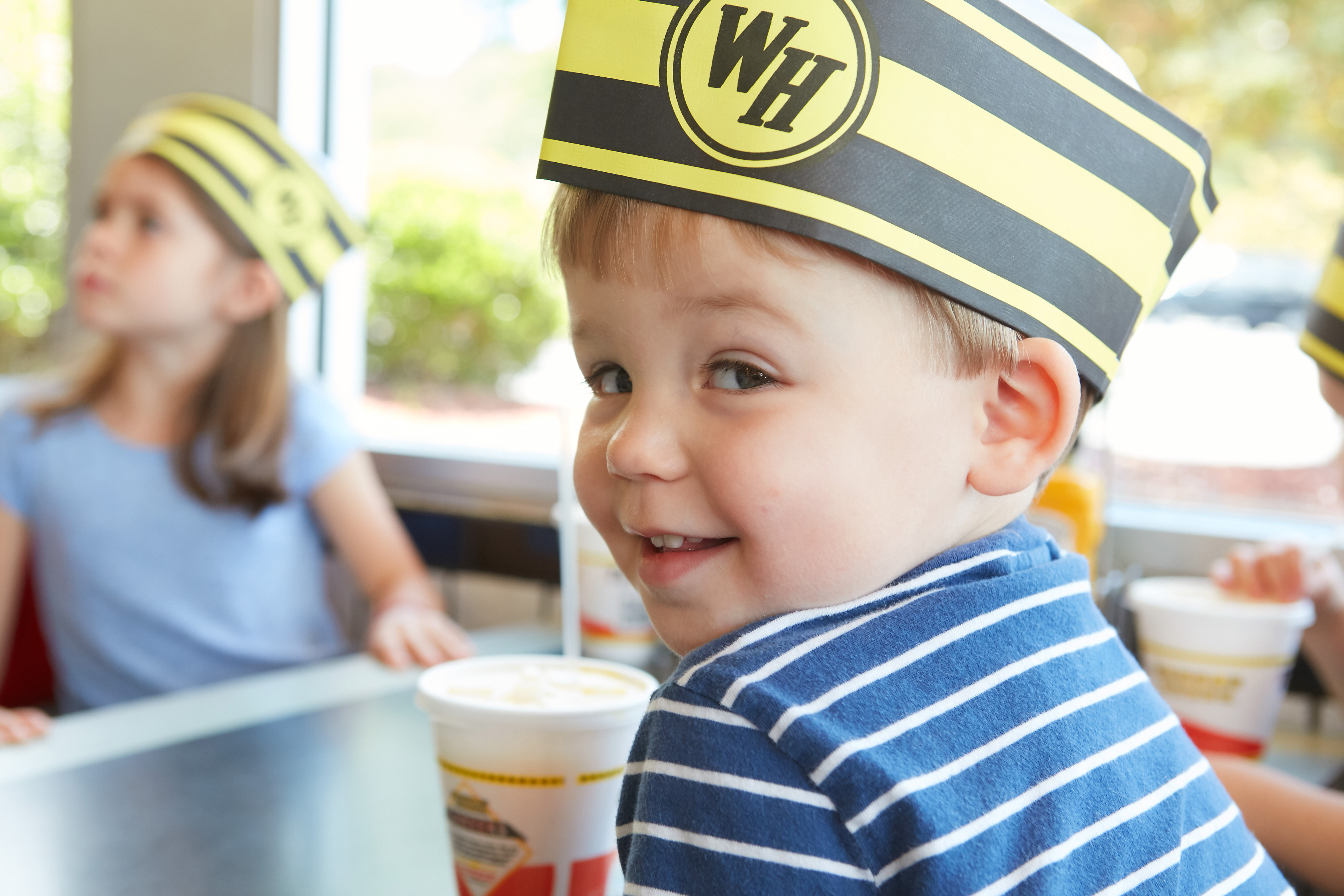 Small child wearing a waffle house hat